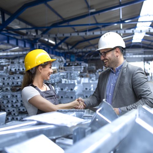 Factory manager visiting production line and congratulating worker for hard work and good results.